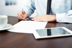 man signing paperwork at table disposition